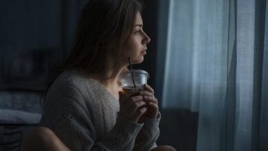 Жінка біля вікна з чаєм