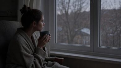 Жінка біля вікна з чаєм